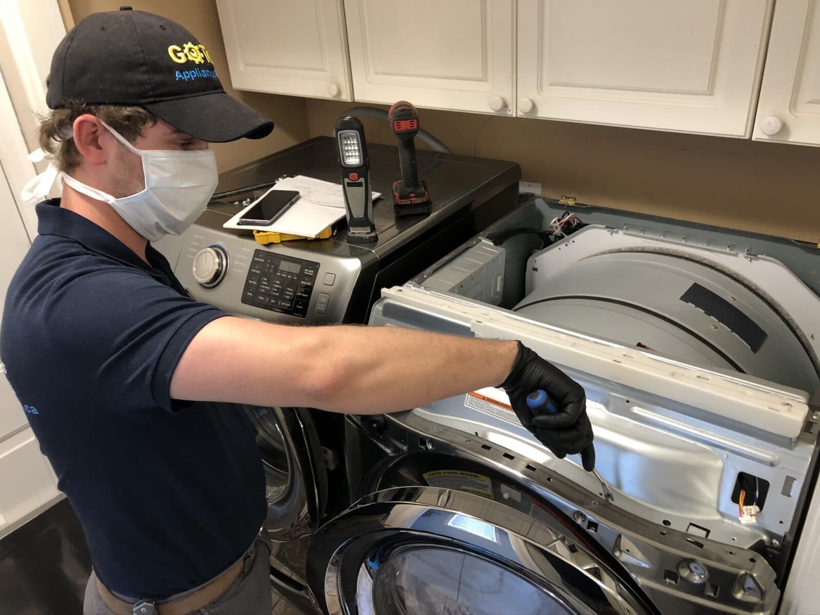 Technician removing the rear panel of a clothes dryer